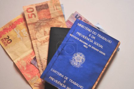 Brazilian Work Card (Carteira de Trabalho), with Brazilian money on a white background