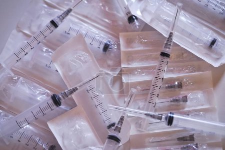syringes over white surface, for medical, healthcare or pharmacy themes.
