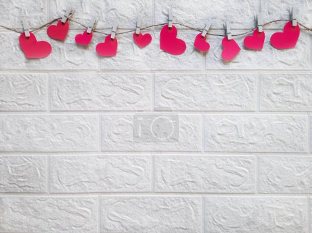Photo for Brick wall decorated with hearts on rope for hen party. Space for text. Team Bride. Theme of organizing and holding bachelorette party. Copy space. Valentines on clothespins. Flat lay. - Royalty Free Image