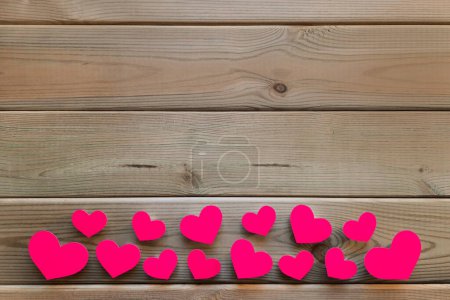 Photo for Valentines on table. Flatlay. Pink heart shaped confetti lies from below on wooden background. Space for text. Mockup for advertisement romance valentine's day, date, engagement. Top view. Copy space. - Royalty Free Image
