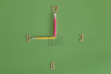 Photo for 9 o'clock, morning. Watch face with the concept of lesson schedule, daily routine at school, kindergarten. Copy space. Unusual green clock face with with marker hour hands. Flat lay. Time for study. - Royalty Free Image