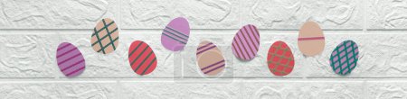 Photo for Banner with Easter eggs made of colored cardboard. Thematic header for kindergarten, school, art class. Multi-colored eggs with pattern cut out of paper on background of white wall. Crafts for kids - Royalty Free Image