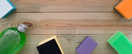 Photo for Banner with goods for cleaning. Flat lay. Concept of spring Deep clean of kitchen. Kitchen cleaning sponges and bottle of household chemicals on wooden background. Copy space. Top view. - Royalty Free Image