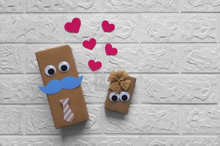 Photo for Cheerful gift boxes. Copy space. Concept of gifts for him and for her. Box boy and box girl with eyes. Flat lay. Gift wrapping idea for valentine's day, wedding, anniversary, twin birthday. - Royalty Free Image