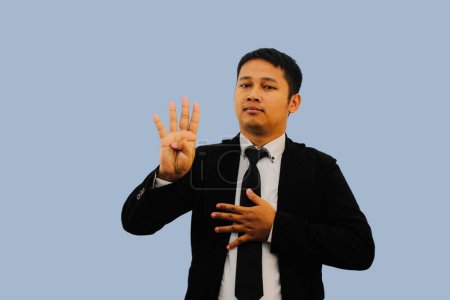 Foto de Adulto asiático hombre sonriendo a la cámara y haciendo cuatro dedos signo - Imagen libre de derechos