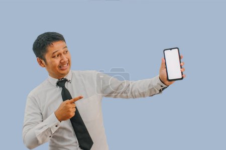 Photo for Side View A man showing excited while pointing to blank phone screen that he hold - Royalty Free Image