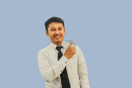 Erwachsener asiatischer Mann lächelt glücklich und zeigt mit dem Finger daneben