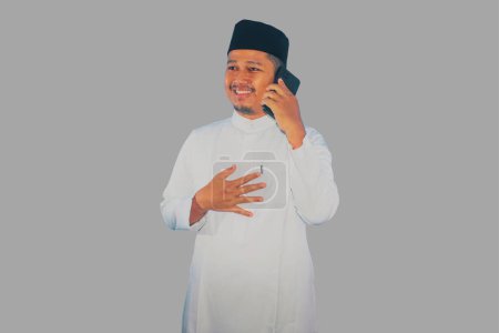 Moslem asiatischer Mann lächelt glücklich, während er seine Familie während des Ramadan anruft