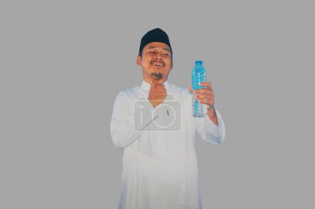 Moslem hält ein Getränk in der Hand und berührt seine Kehle mit erleichterter Miene
