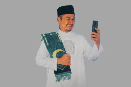 Photo for Moslem Asian man smiling to give greeting during Ramadan celebration - Royalty Free Image