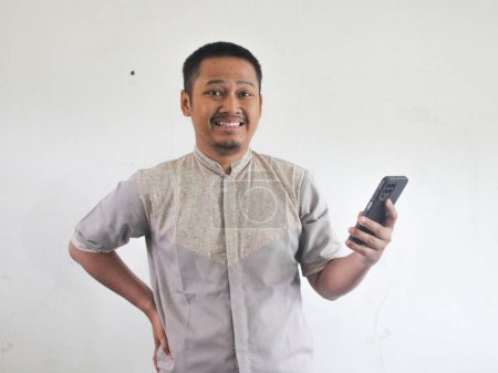 Foto de Adulto asiático hombre sonriendo mientras usa el teléfono móvil - Imagen libre de derechos