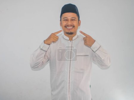 Moslem Asian man pointing to his mouth with happy expression