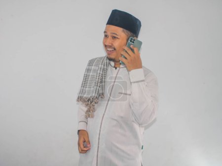 Téléchargez les photos : Musulman asiatique sourire heureux tout en appelant sa famille pendant la célébration du Ramadan - en image libre de droit