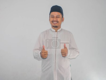 Téléchargez les photos : Musulman asiatique l'homme souriant heureux et donner deux pouce vers le haut - en image libre de droit