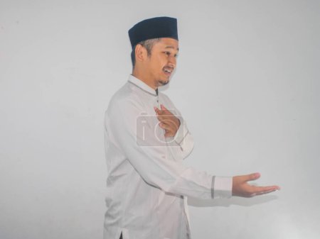 Vue latérale musulman asiatique homme souriant amical lors de l'offre poignée de main