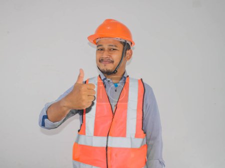 Ouvrier de la construction souriant et abandonnant le pouce