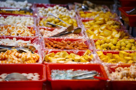 a variety of vibrant hot pot ingredients, neatly arranged in red plastic boxes