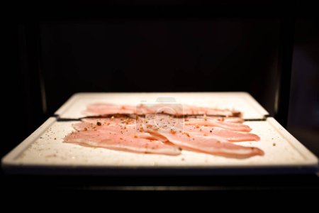 a plate where freshly prepared meat slices are being served