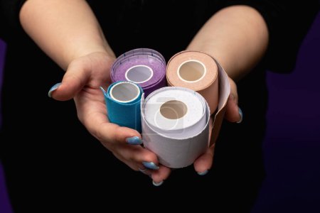Kinesio tape in hands to support the muscles of the face and body. Aesthetic taping concept. Face taping, cosmetological tape. anti-aging lifting. Skin care. Weight loss. Alternative treatment. Fit