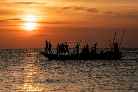 Téléchargez les photos : Dar es Salaam, Tanzanie - Mars 2023 : Des pêcheurs locaux sont en train de pêcher sur un vieux bateau. Photo de haute qualité - en image libre de droit