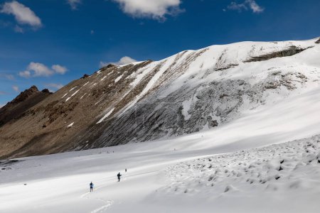 Téléchargez les photos : Groupe d'alpinistes marchant sur le terrain montagneux de Kailash Plusieurs membres de l'équipe. Photo de haute qualité - en image libre de droit