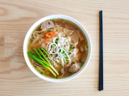 Téléchargez les photos : Image sélective de la soupe dans un bol blanc avec un bâton noir sur la table en bois. vue d'en haut - en image libre de droit