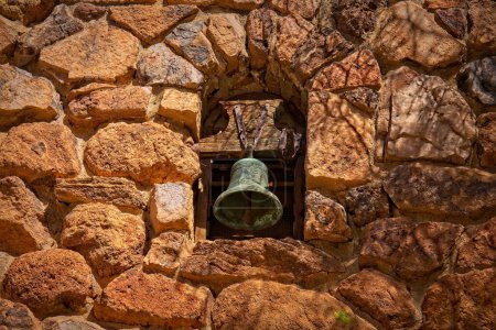 Téléchargez les photos : Une cloche de mission patinée posée dans un vieux mur de pierre de roches rougeâtres à l'Arboretum Boyce Thompson, Arizona. - en image libre de droit