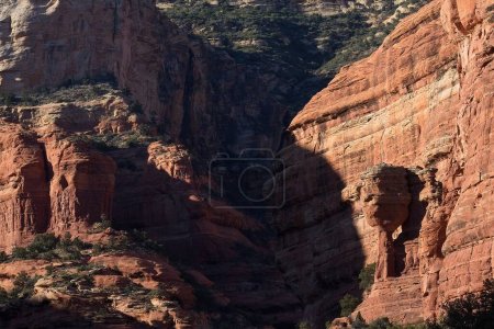 Téléchargez les photos : Étrange colonne rocheuse à Fay Canyon, dans les Rochers Rouges de Sedona, Arizona. Genévrier vert poussent au premier plan. - en image libre de droit