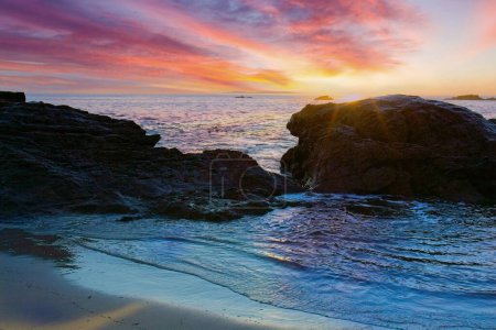 Téléchargez les photos : Brilliant sunset with rocks and water in the foreground at Laguna Beach, California - en image libre de droit