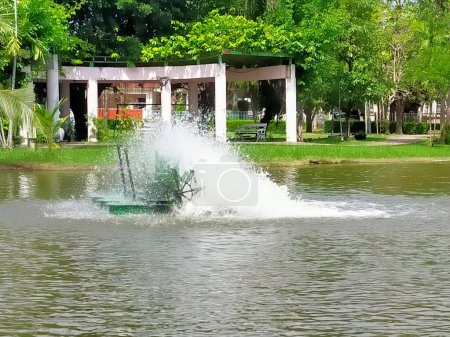 Téléchargez les photos : Un aérateur de surface fonctionne dans un étang du parc. - en image libre de droit