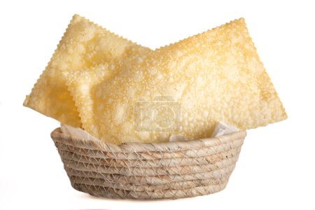 Two pastel (traditional Brazilian fried pastry) on a basket, isolated, white background