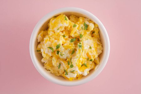 Photo for Scrambled eggs on bowl, pink background, soft light, top view - Royalty Free Image