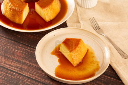Photo for Creme Caramel Condensed Milk Pudim slice in front view with wood background - Royalty Free Image