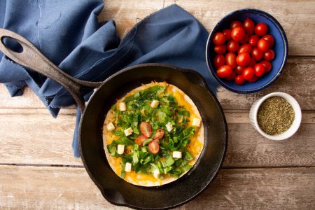 Photo for Cheesy Arugula Pizza with Cherry Tomatoes in Cast Iron Skillet - Royalty Free Image