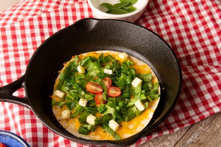 Photo for Cheesy Arugula Pizza with Cherry Tomatoes in Cast Iron Skillet - Royalty Free Image