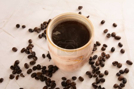 Coffee mug in a marbled stone background with coffee beans marble surface in aerial view