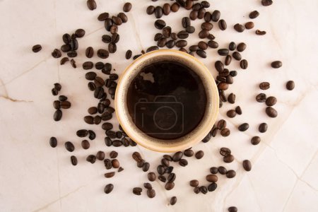 Coffee mug in a marbled stone background with coffee beans marble surface in aerial view