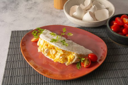 Panqueque de Tapioca con huevos Comida brasileña de mandioca en plato rojo vista frontal superior