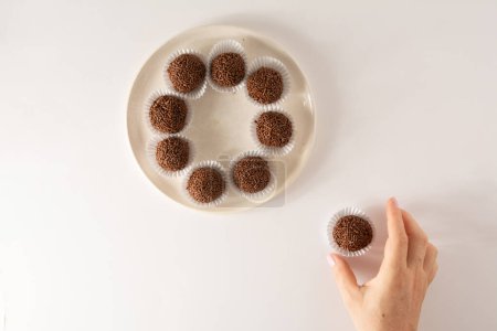 Schokolade Trüffelkugeln Brigadeiro brasilianischen Bonbons und Schokoladenflocken Luftbild weißer Hintergrund