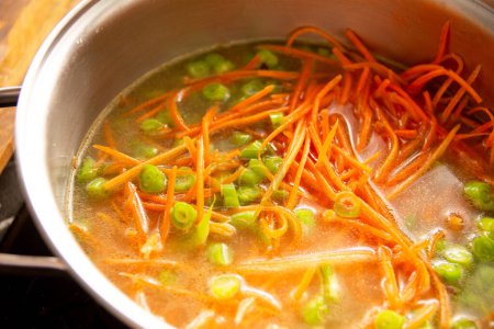 Bowl of fresh vegetable soup with carrots and green beans