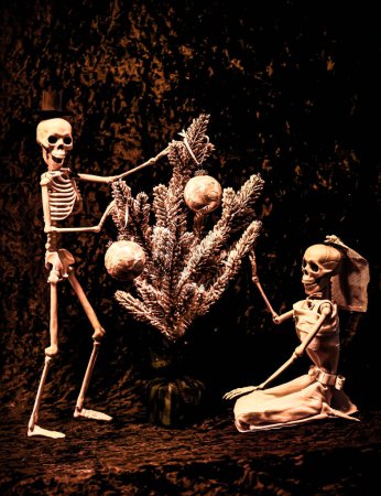 Photo for Skeleton Bride and Groom Decorating a Christmas Tree for the Holidays - Royalty Free Image