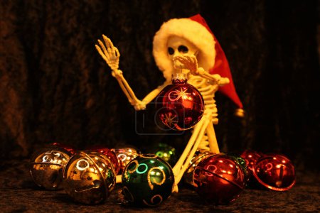 Foto de Este esqueleto sostiene una bola de Navidad mientras ordena adornos - Imagen libre de derechos