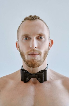 Photo for Portrait of handsome caucasian athletic young man topless in leather bow tie. Fitness, bodybilding - Royalty Free Image