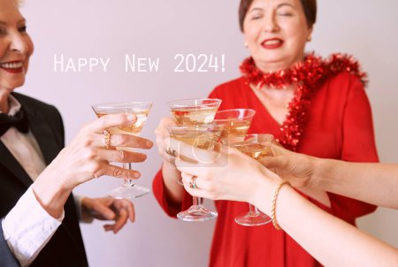 Téléchargez les photos : Nouvelle année célébrant les mains avec des verres de vin mousseux blanc. Noël, famille, amis, célébration, concept de nouvelle année - en image libre de droit