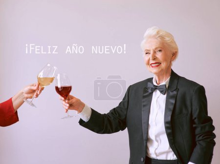 Téléchargez les photos : Sommelier senior élégant femme en smoking avec verre ou vin rouge à la fête. Boisson, mature, style, concept d'amitié - en image libre de droit