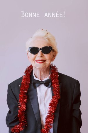 Foto de Hermosa mujer mayor madura con estilo en gafas de sol y esmoquin celebrando el año nuevo. Diversión, fiesta, estilo, concepto de celebración - Imagen libre de derechos