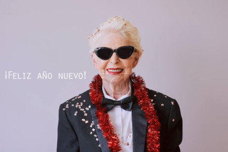Téléchargez les photos : Belle femme âgée mature élégante en lunettes de soleil et smoking célébrant le nouvel an. Fun, fête, style, concept de célébration - en image libre de droit