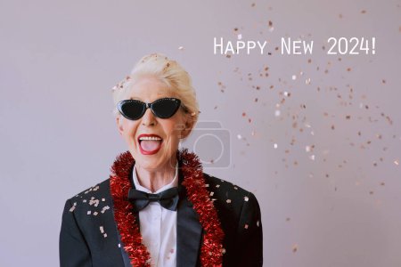 Foto de Hermosa mujer mayor madura con estilo en gafas de sol y esmoquin celebrando el año nuevo. Diversión, fiesta, estilo, concepto de celebración - Imagen libre de derechos