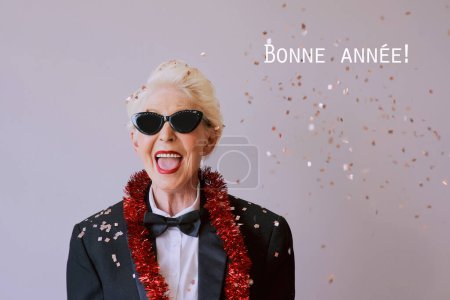 Téléchargez les photos : Belle femme âgée mature élégante en lunettes de soleil et smoking célébrant le nouvel an. Fun, fête, style, concept de célébration - en image libre de droit