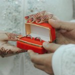 A pair of rings are held by the bride and groom